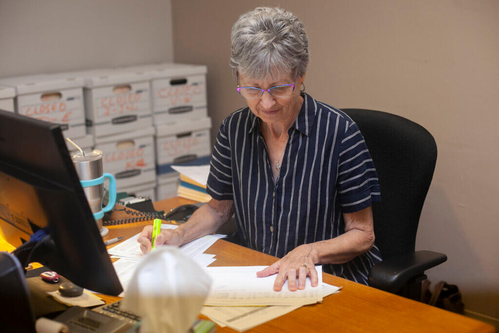 woman highlighting a document at desk